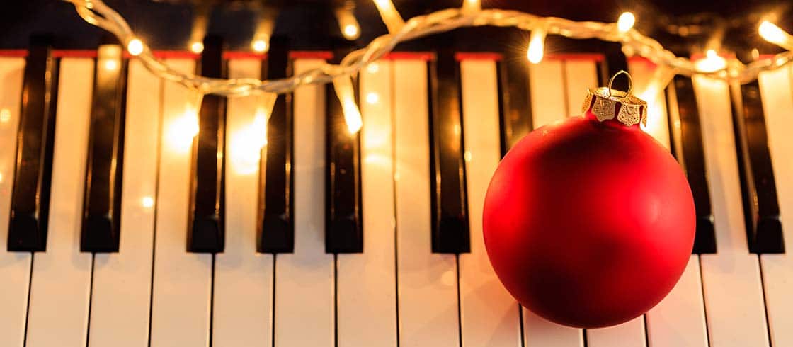 Christmas ball and lights on a classical piano keyboard, above view