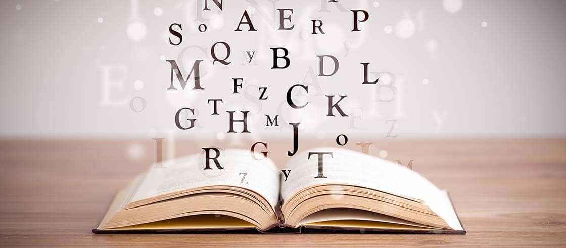 Opened book with flying letters on concrete background