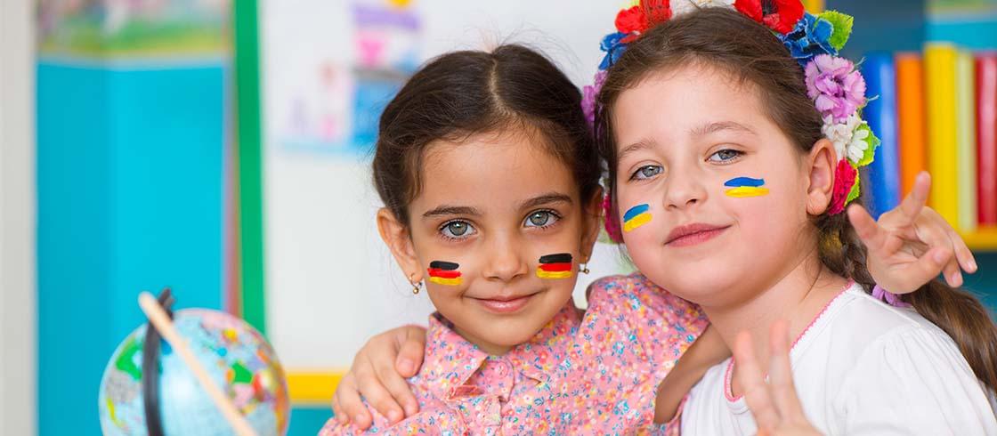 Zwei Mädchen mit auf die Wangen geschminkten deutschen und ukrainischen Flaggen
